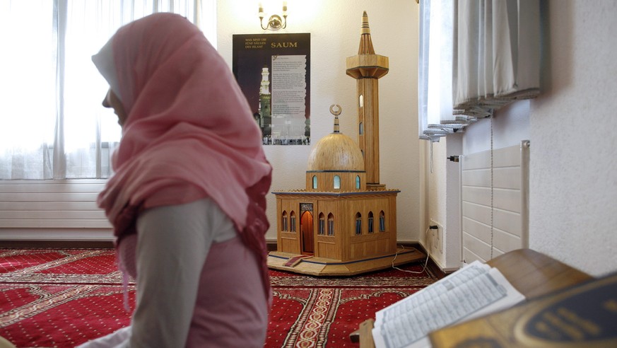 Eine Frau im Zentrum Roetelstrasse der Islamischen Gemeinschaft Zuerich in Zuerich, aufgenommen am 1. April 2007. (KEYSTONE/Alessandro Della Bella)

A muslim sits in front of a model of a mosque in th ...