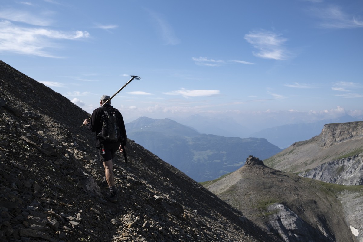 Beat Jaeger traegt einen Rechen zum Wegunterhalt des Wanderweges auf den Calanda (2805 Meter ueber Meer), aufgenommen auf der St. Galler Seite des Berges, am Freitag, 26. Juli 2024, in Vaettis. (KEYST ...