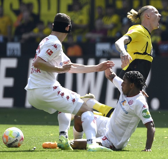 epa10657524 Marius Wolf of Borussia Dortmund in action against Dominik Kohr (L) and Leandro Barreiro (bottom) of Mainz 05 during the German Bundesliga match between Borussia Dortmund and Mainz 05 in D ...