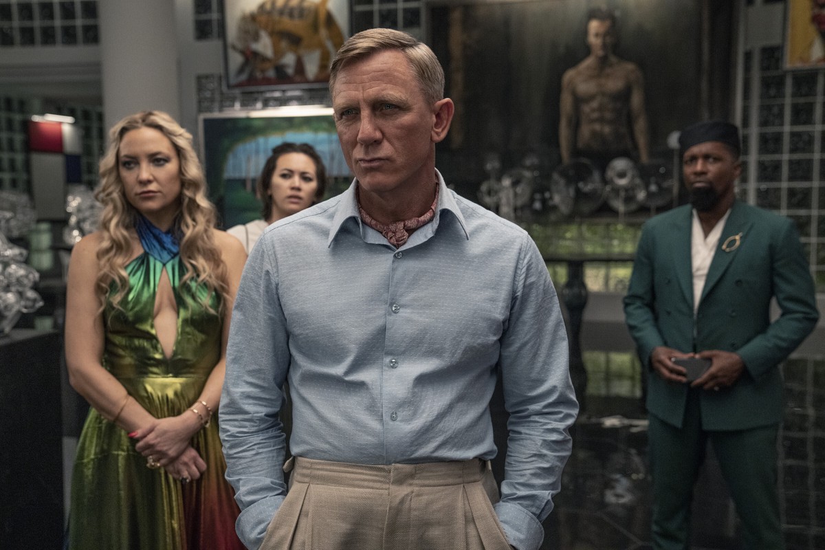 This image released by Netflix shows Kate Hudson, from left, Jessica Henwick, Daniel Craig and Leslie Odom Jr. in a scene from "Glass Onion: A Knives Out Mystery." (John Wilson/Netflix via A ...