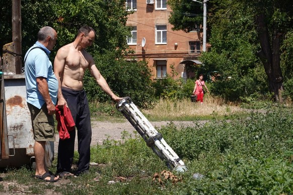 SLOVIANSK, UKRAINE - JUNE 27: Residents look over remains of a missile that dropped cluster bombs in a residential housing complex on June 27, 2022 in Sloviansk, Ukraine. The attack, which occurred ab ...