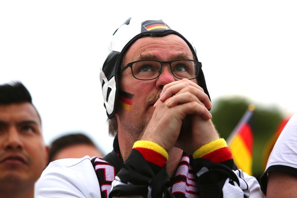 epa06844261 A German fan watches the FIFA World Cup 2018 match between Germany and South-Korea at the public viewing area in front of the Brandenburg Gate in Berlin, Germany, 27 June 2018. EPA/OMER ME ...