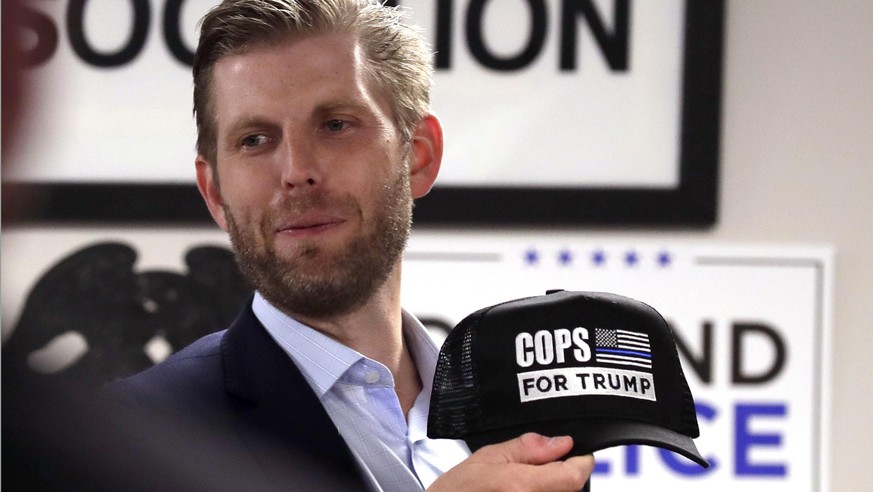 Eric Trump, son of President Donald Trump, gives away a hat before he speaks at the Milwaukee Police Association, Tuesday, Aug. 18, 2020, in Milwaukee. (Rick Wood/Milwaukee Journal-Sentinel via AP)