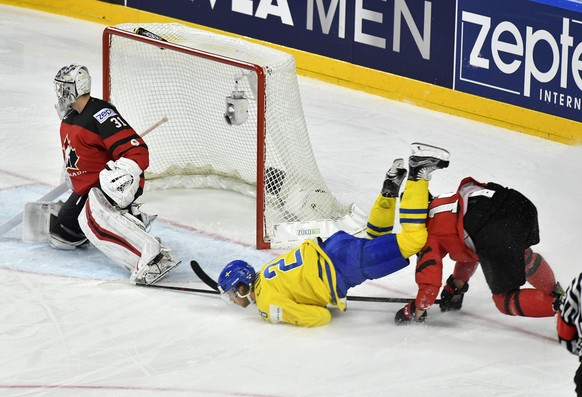 Sweden&#039;s Joel Eriksson Ek falls over Canada&#039;s Mike Matheson, right, at the Ice Hockey World Championships final match between Canada and Sweden in the LANXESS arena in Cologne, Germany, Sund ...