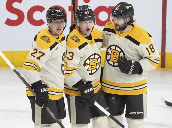 Boston Bruins&#039; Danton Heinen, center, celebrates after his goal against the Montreal Canadiens with teammates Hampus Lindholm (27) and Pavel Zacha (18) during first-period NHL hockey game action  ...