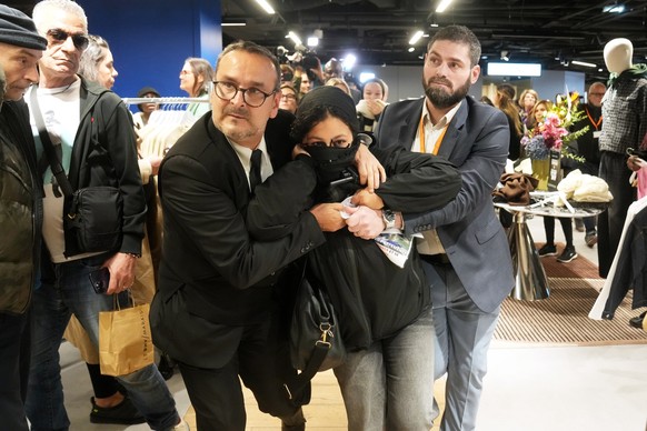 A protester is being evacuated from the BHV department store as fast fashion Shein opens its first physical store, Wednesday, Nov. 5, 2025 in Paris. (AP Photo/Thibault Camus)