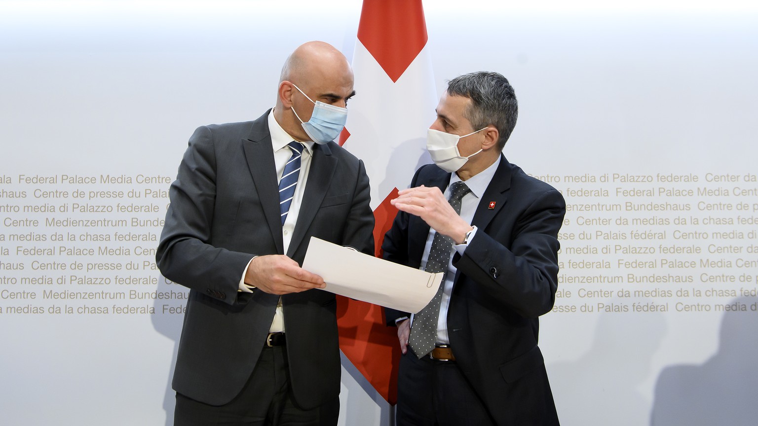 Bundesrat Alain Berset, links, und Bundespraesident Ignazio Cassis, rechts, sprechen nach einer Medienkonferenz ueber die neusten Entscheide des Bundesrates zur Coronavirus-Pandemie, am Mittwoch, 16.  ...