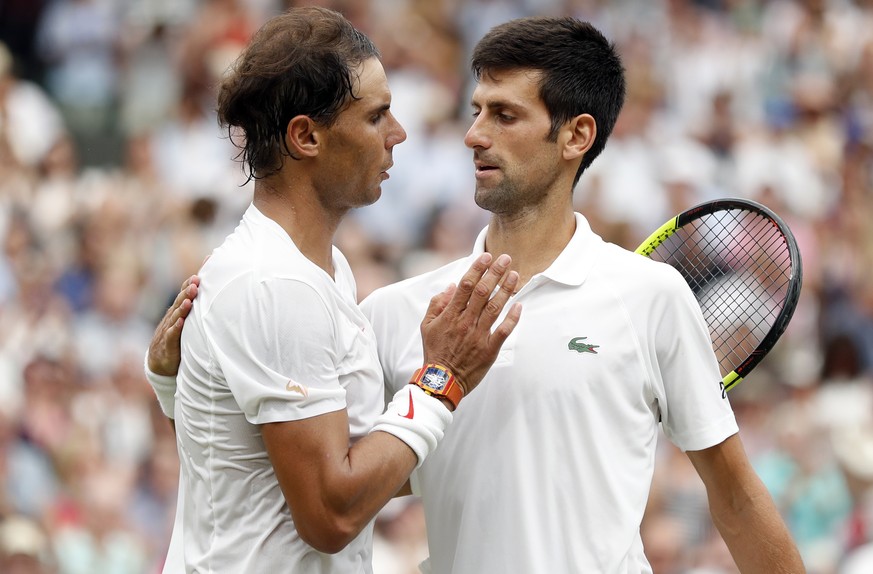 epa06888312 Novak Djokovic of Serbia (R) at the net with Rafael Nadal of Spain whom he defeated in their semi final match during the Wimbledon Championships at the All England Lawn Tennis Club, in Lon ...