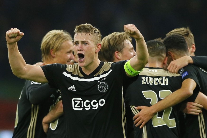 Ajax&#039;s captain Matthijs de Ligt clenches his fists as his teammates join in celebrating their 1-0 victory during a Group E Champions League soccer match between Ajax and Benfica at the Johan Cruy ...