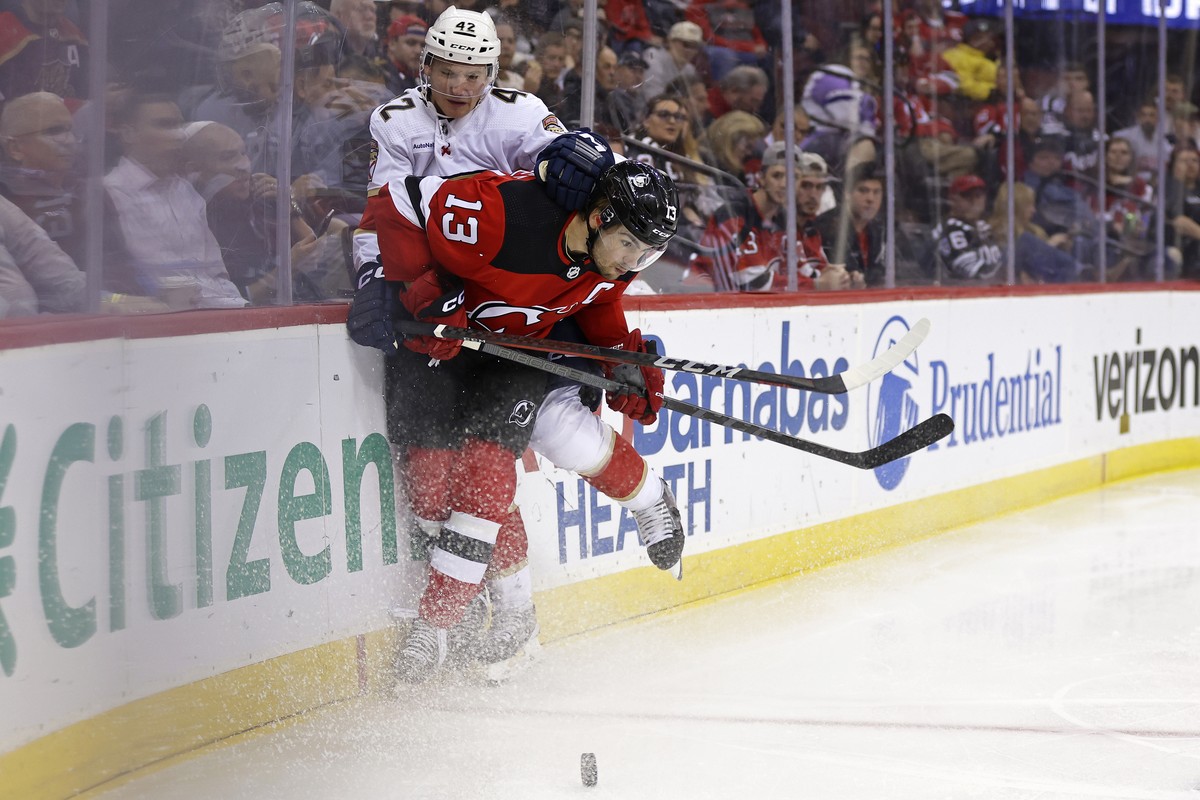 New Jersey Devils center Nico Hischier (13) checks Florida Panthers defenseman Gustav Forsling (42) in the second period of an NHL hockey game, Monday, Oct. 16, 2023, in Newark, N.J. (AP Photo/Adam Hu ...