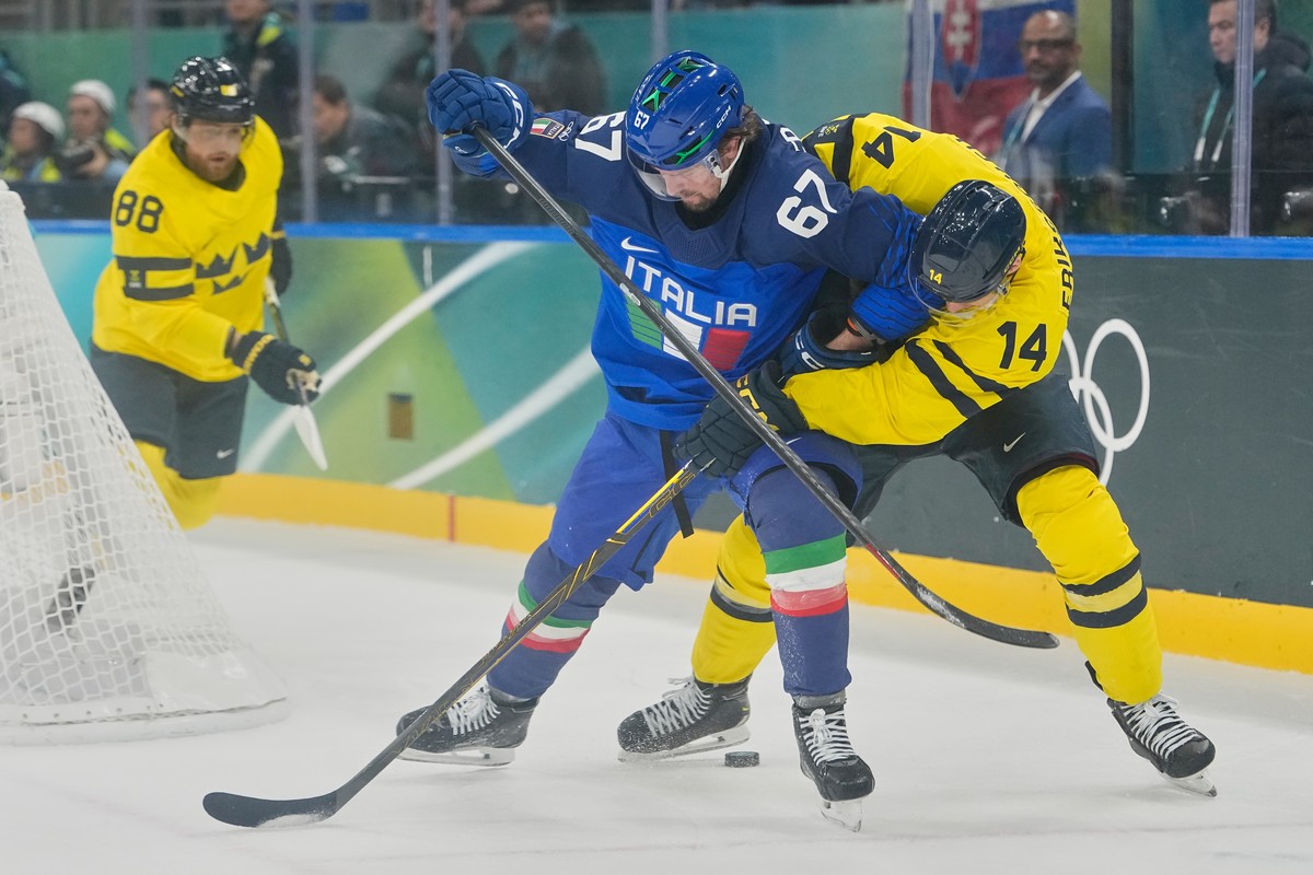 Italy's Mats Frycklund (67), left, challenges Sweden's Joel Eriksson Ek (14)during a preliminary round match of men's ice hockey between Italy and Sweden at the 2026 Winter Olympics, in ...
