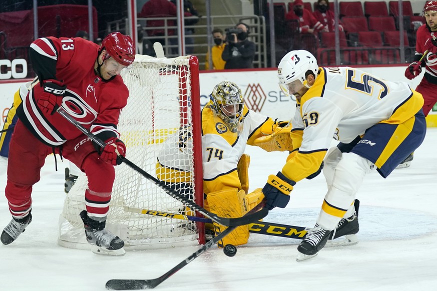 Nashville Predators goaltender Juuse Saros (74) and defenseman Roman Josi (59) defend against Carolina Hurricanes left wing Warren Foegele (13) during the second period of an NHL hockey game in Raleig ...