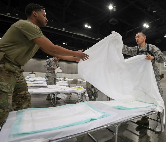 In this Sunday March 29, 2020 provided by the Office Of Mayor Garrcetti National Guard troops set up beds as a medical station to help relieve nearby hospitals as they fight COVID-19 and coronavirus,  ...