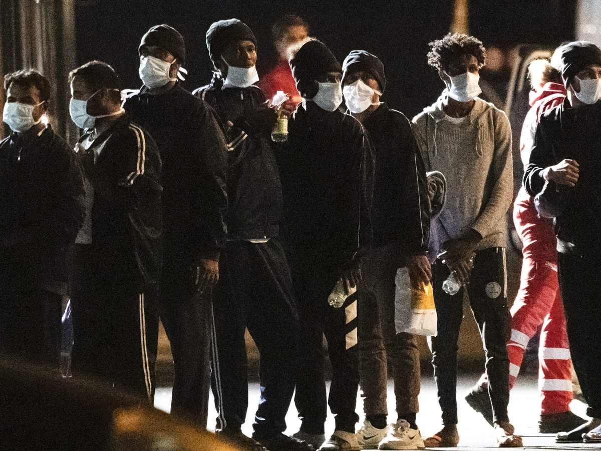 Migrants disembark from the Norway-flagged Geo Barents rescue ship after having been allowed by Italian authorities, in Catania's port, Sicily, southern Italy, Tuesday, Nov. 8, 2022. While the Ge ...