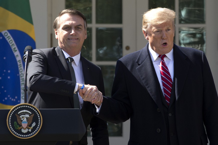 epa07448947 US President Donald J. Trump (R) and Brazilian President Jair Bolsonaro (L) shake hands at the conclusion of their joint news conference in the Rose Garden of the White House in Washington ...