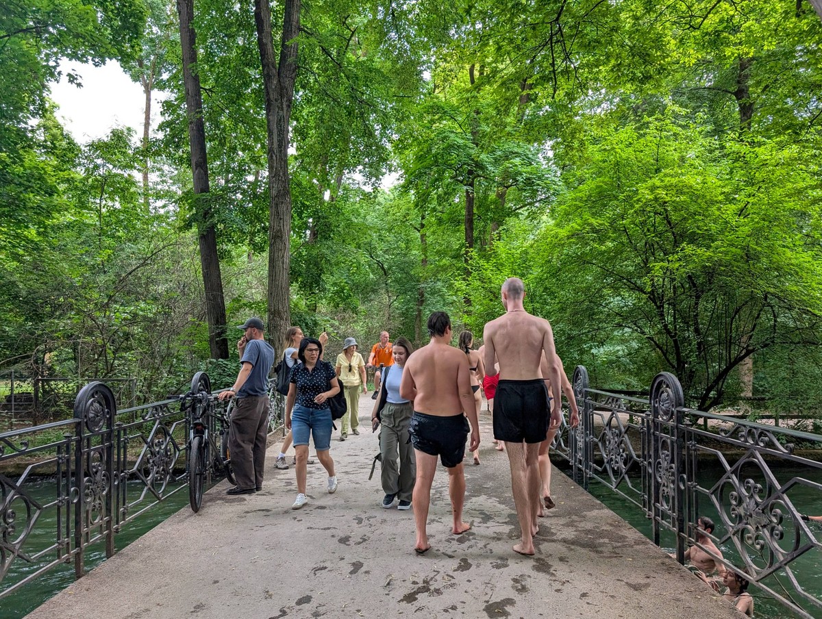 Young People Cooling Off In The Eisbach In Munich Young people return from swimming in the fast-flowing Eisbach stream in Munich, Germany, on July 6, 2025. Munich Germany PUBLICATIONxNOTxINxFRA Copyri ...