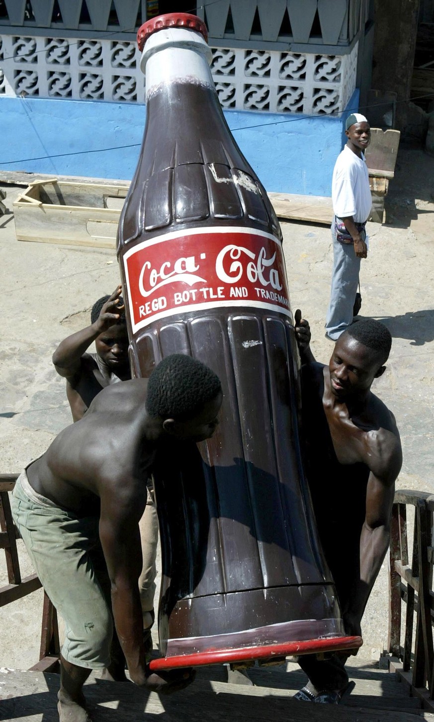 -PHOTO TAKEN 22JAN06- Carpenters carry a coffin shaped in the form of a Ghana Airways aircraft to their showroom in Teshie, a suburb of the Ghanaian capital of Accra, January 22, 2004. Funerals are im ...