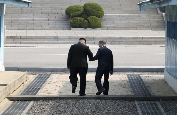 North Korean leader Kim Jong Un, left, and South Korean President Moon Jae-in cross the border line at the border village of Panmunjom in Demilitarized Zone Friday, April 27, 2018. Their discussions w ...