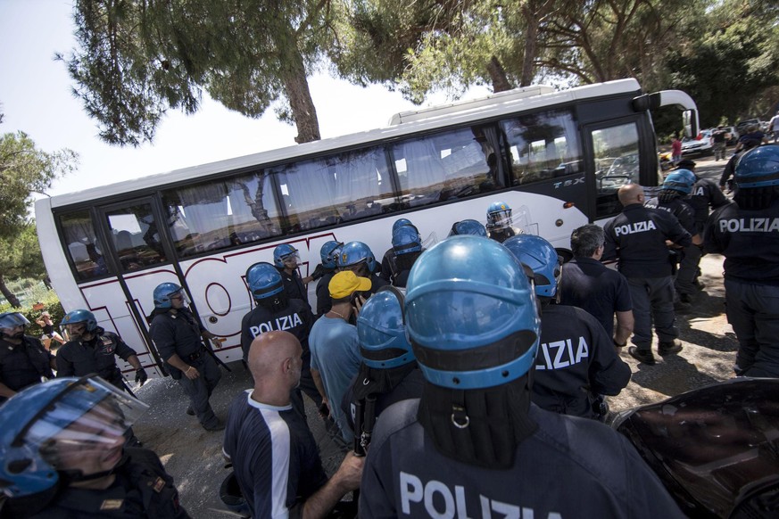 Ein Bus mit Flüchtlingen muss in Rom von Polizisten beschützt werden.