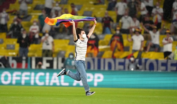 epa09296697 A pitch invader carrying a rainbow flag runs onto the pitch before the UEFA EURO 2020 group F preliminary round soccer match between Germany and Hungary in Munich, Germany, 23 June 2021. E ...