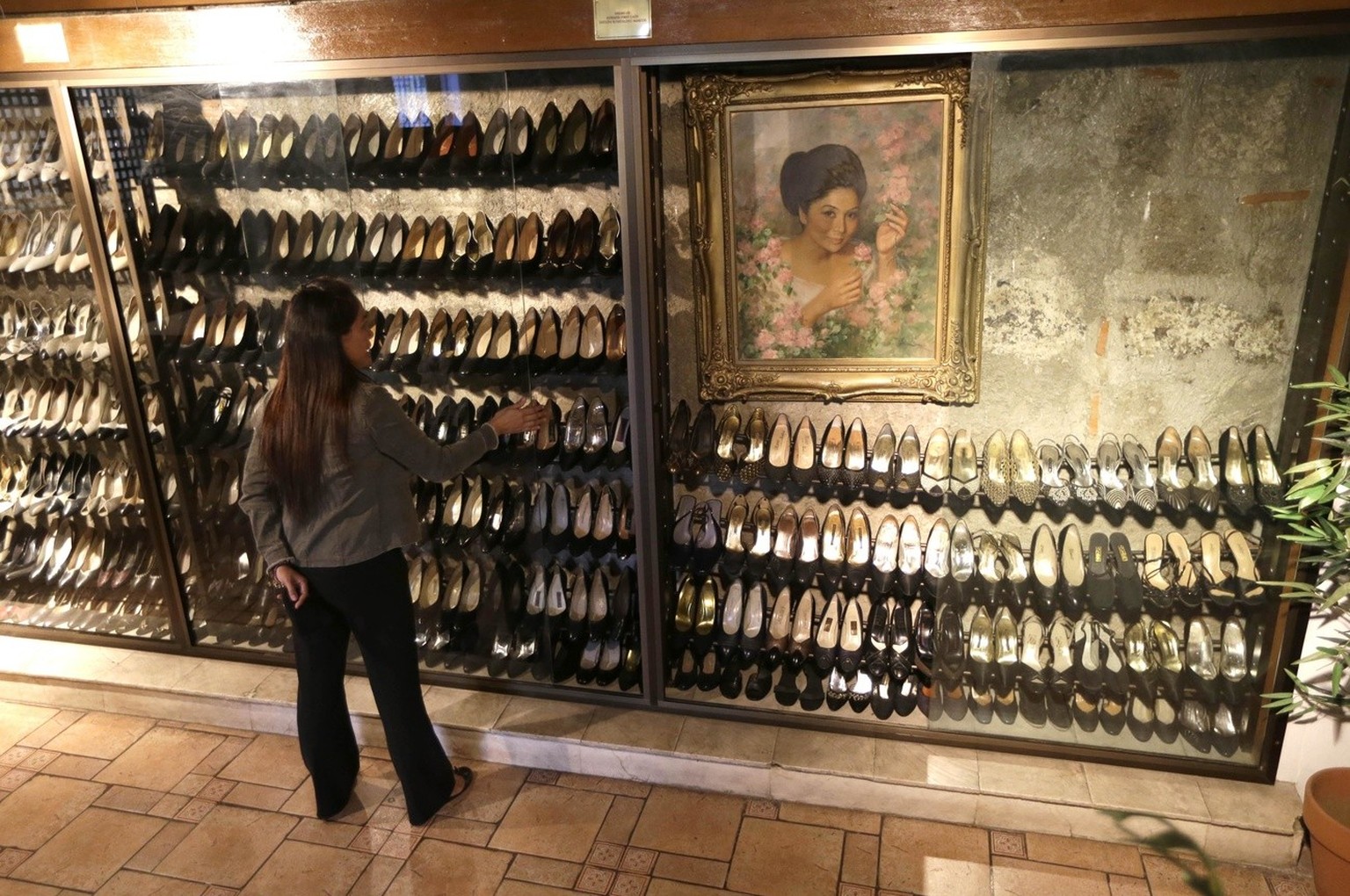 Jane Ballesteros, the curator of Marikina Museum where more than 700 pairs of shoes of former Philippine First Lady Imelda Marcos are displayed, checks a display Tuesday Sept. 25, 2012 at Marikina cit ...