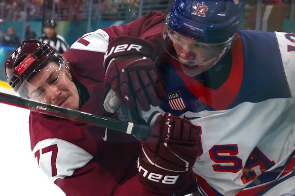 epa12732757 Matt Boldy (R) of USA vies for the puck against.Kristaps Roberts Zile (L) of Latvia during the Men's Women's Preliminary Round match Latvia against the USA of the Ice Hockey comp ...