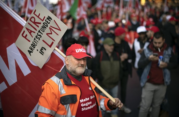 Ein Bauarbeiter protestiert mit einem Plakat mit der Aufschrift &quot;Faire Arberitsstunden im LMV&quot; waehrend einer Verpflegungspause im Zuercher Hauptbahnhof gegen die Verschlechterung der Arbeit ...