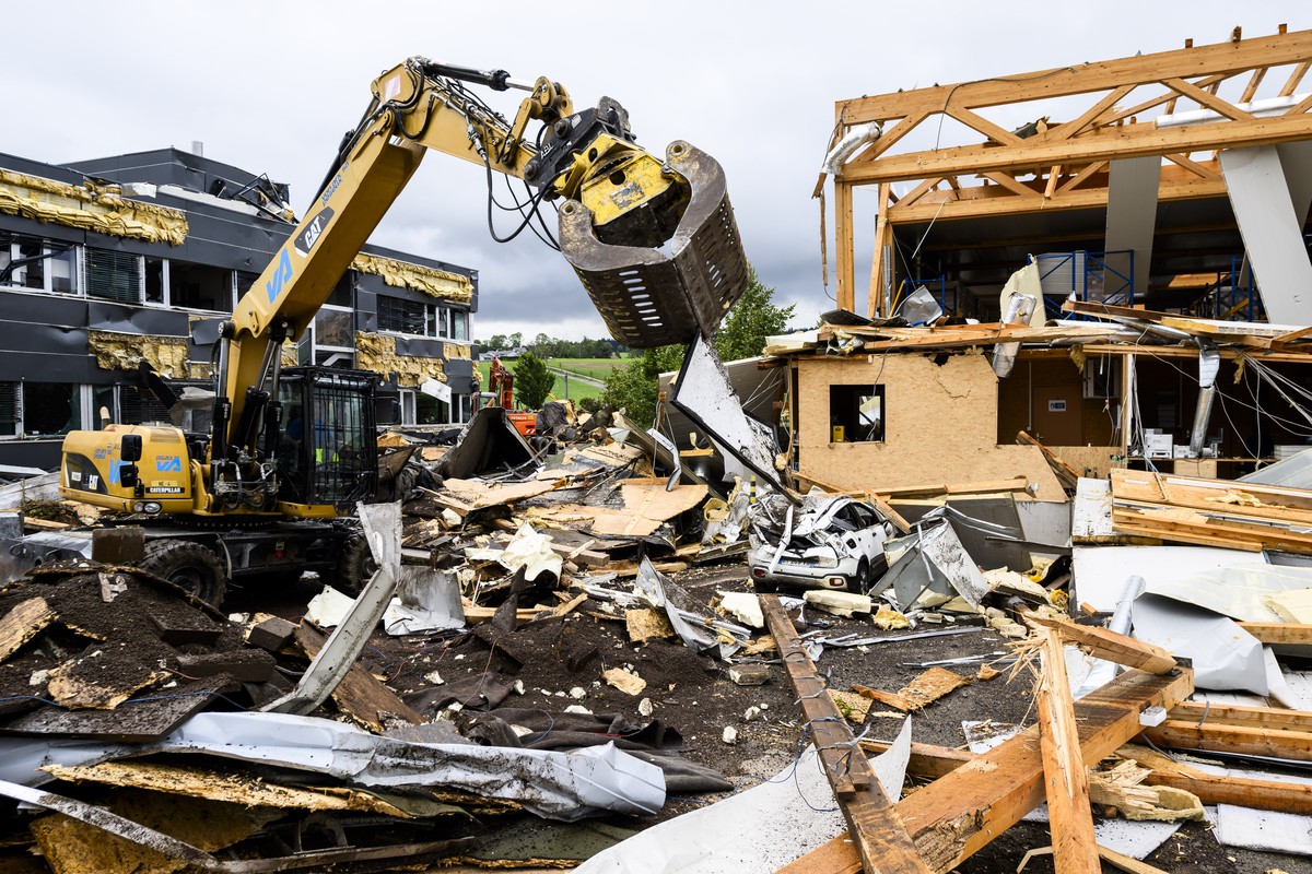 Des ouvriers enlevent les debris entre l'entreprise Sellita Watch et l'entreprise La Semeuse, un jour apres le passage de la forte tempete le mardi 25 juillet 2023 au Cret-du-Locle a cote de ...
