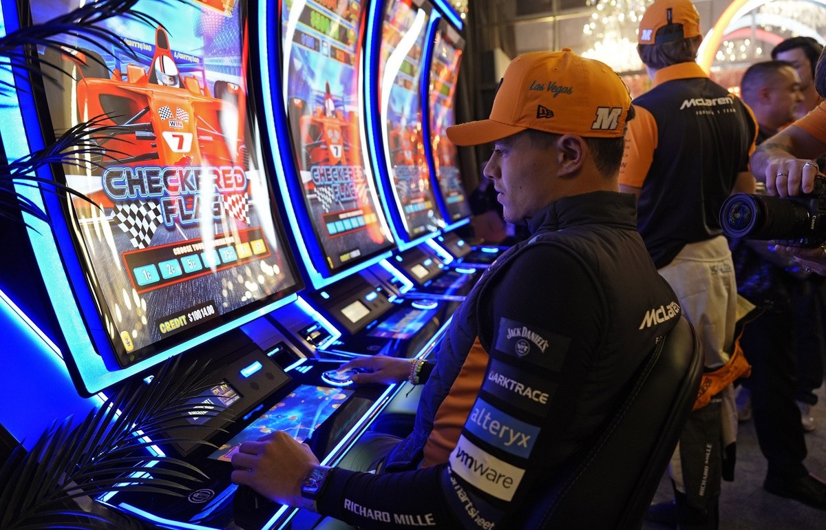 Lando Norris (McLaren), assis aux machines à sous dans un casino de la cité du jeu.