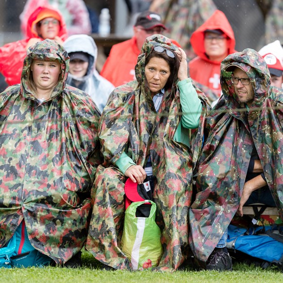 Zuschauer sitzen im Regen beim Ob- und Nidwaldner Kantonal Schwingfest am Sonntag, 22. August 2021 in Giswil. (KEYSTONE/Philipp Schmidli)