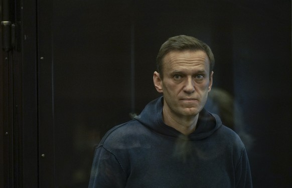 epa08980966 A handout photo made available by Moscow's Citiy Court Press Service shows Russian opposition leader Alexei Navalny (L) standing in the glass cage during a hearing in the Moscow City ...