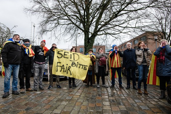 epa06642888 Sympathizers of former Catalan leader Carles Puigdemont, amongst them Josep Maria Matamala (3-R), a businessman and confidant, pose, sing and shout slogans while holding a banner reading & ...