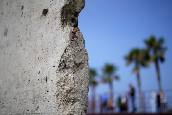 A slab of the Berlin Wall is displayed near the border wall separating the United States from Mexico, in Tijuana, Mexico, Friday, Aug. 25, 2023. Shards of the Berlin Wall scattered worldwide after it  ...