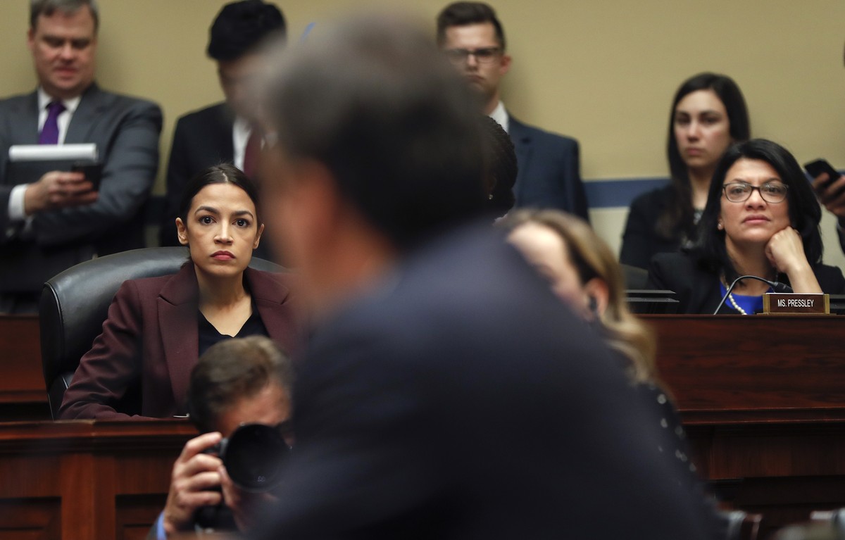 Committee members Rep. Alexandria Ocasio-Cortez, D-N.Y.,, left, and Rep. Rashida Tlaib, D-Mich., right, listen to Michael Cohen, center, President Donald Trump's former lawyer, testimony before t ...