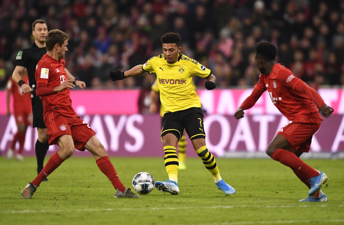 epa07984315 Bayern's Thomas Mueller (L) and Dortmund's Jadon Sancho (C) in action during the German Bundesliga soccer match between FC Bayern Munich and Borussia Dortmund in Munich, Germany, ...