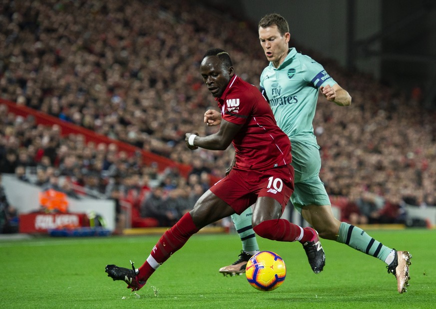 epa07253288 Liverpool&#039;s Sadio Mane (L) in action with Arsenal&#039;s Stephan Lichtsteiner (R) during the English Premier League soccer match between Liverpool and Arsenal at the Anfield in Liverp ...
