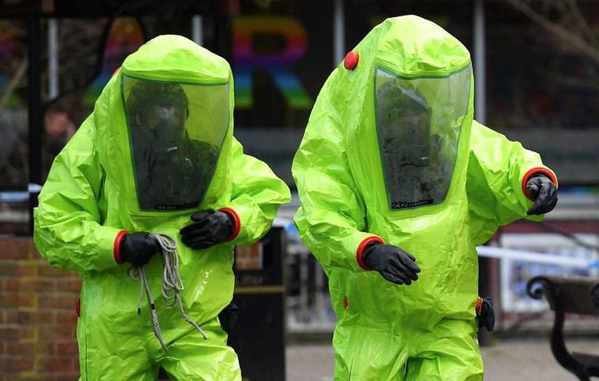 (FILES) In this file photo taken on March 08, 2018 members of the emergency services in green biohazard encapsulated suits work to afix the tent over the bench where former Russian spy Sergei Skripal  ...