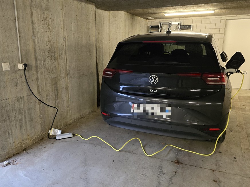 Ein Auto lädt per Notladekabel an der Steckdose.