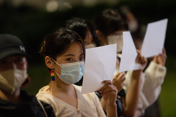epa10336071 Mainland Chinese students hold sheets of blank paper during a vigil for the victims of China