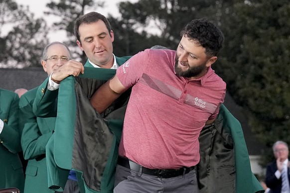 Scottie Scheffler puts the green jacket on Jon Rahm, of Spain, after he won the Masters golf tournament at Augusta National Golf Club on Sunday, April 9, 2023, in Augusta, Ga. (AP Photo/David J. Phill ...