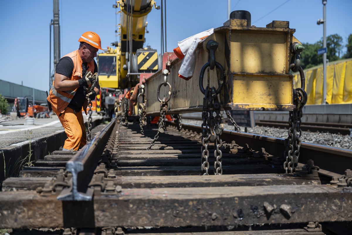 Ein Arbeiter befestigt am Bahnhof Schmitten geloeste Geleise an einem Kran, bevor sie aus dem Schotterbett entfernt werden, am Sonntag, 29. Juni 2025. Vom 27.?Juni bis 25.?August?2025 fuehrt die SBB a ...