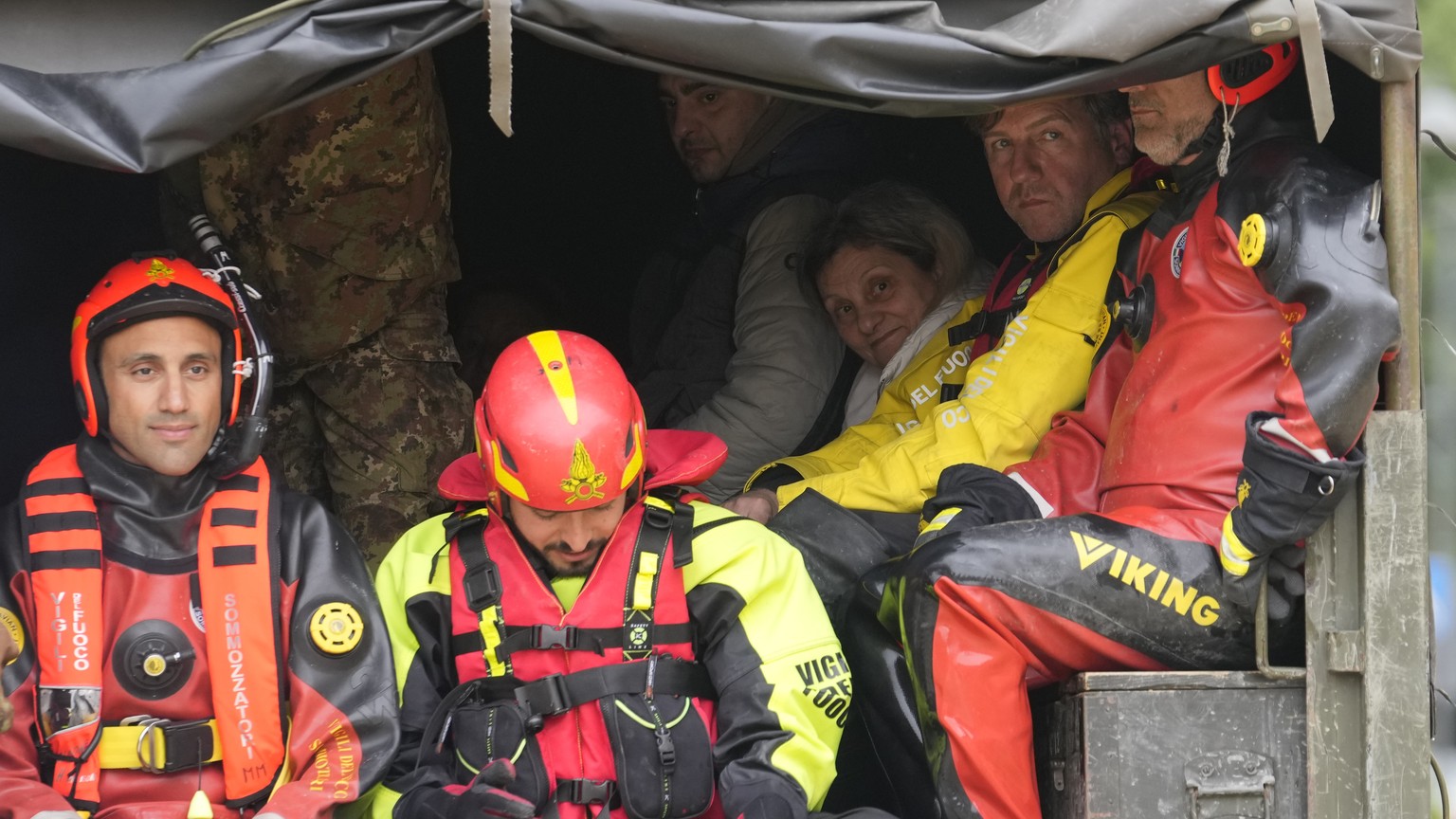 FILE - People sit on a truck after being rescued by firefighters in the village of Castel Bolognese, Italy, May 17, 2023. The floods that sent rivers of mud tearing through towns in Italy?s northeast  ...