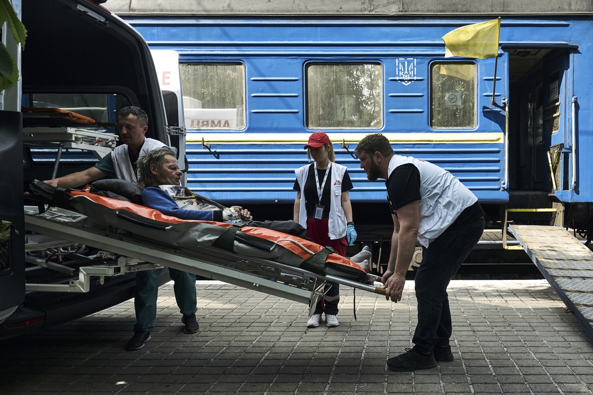 Medical workers carry a patient into a specially equipped railway carriage as the Red Cross evacuates sick people from the war-hit Donetsk region in Pokrovsk, Ukraine, Thursday, May 18, 2023. (AP Phot ...