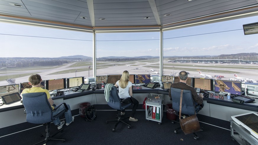 Mitarbeiter von Skyguide kontrolliert die Monitore und hat Blick auf das Flugfeld, bei Skyguide im Tower des Flughafen Zuerich Kloten, aufgenommen am 10. April 2014. Im Tower am Flughafen Zuerich uebe ...