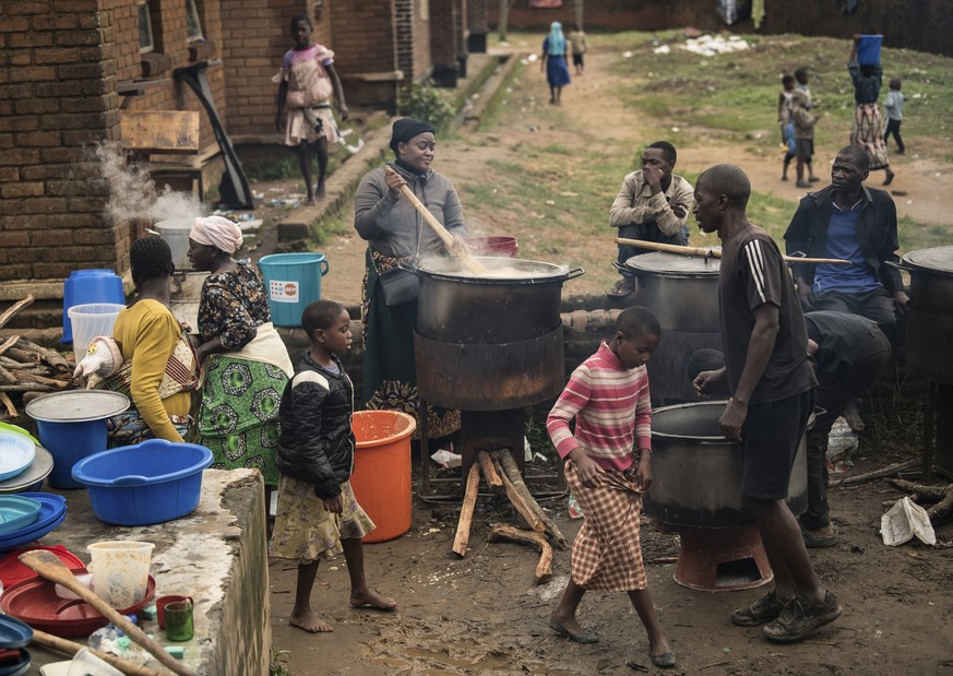 Community volunteers prepare meals for people who were displaced following heavy rains by tropical Cyclone Freddy at Manja displacement centre in Blantyre, southern Malawi, Thursday, March 16, 2023. A ...