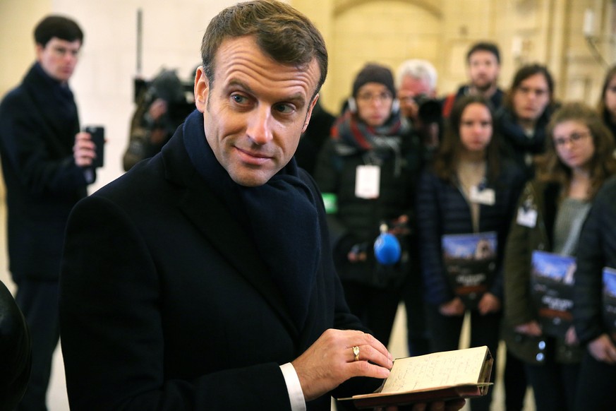 epa07995474 French President Emmanuel Macron reads a WWI &#039;poilu&#039; soldier&#039;s diary during a visit to the World War I (WWI) Battle of the Marne Memorial in Dormans, France, 14 November 201 ...