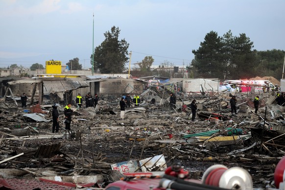 epa05684030 Members of the Mexican Civil Protection work at the site of an explosion, at a fireworks market in the municipality of Tultepec, Mexico, 20 December 2016. According to State of Mexico gove ...