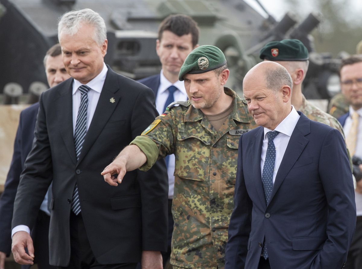 German Chancellor Olaf Scholz, right, and Lithuania's President Gitanas Nauseda, left, listen to Lieutenant Colonel Daniel Andra, the commander of the multi-national NATO Enhanced Forward Presenc ...