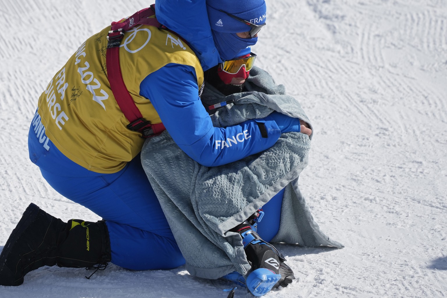 France's Delphine Claudel is comforted after finishing the women's 30km mass start free cross-country skiing competition at the 2022 Winter Olympics, Sunday, Feb. 20, 2022, in Zhangjiakou, C ...