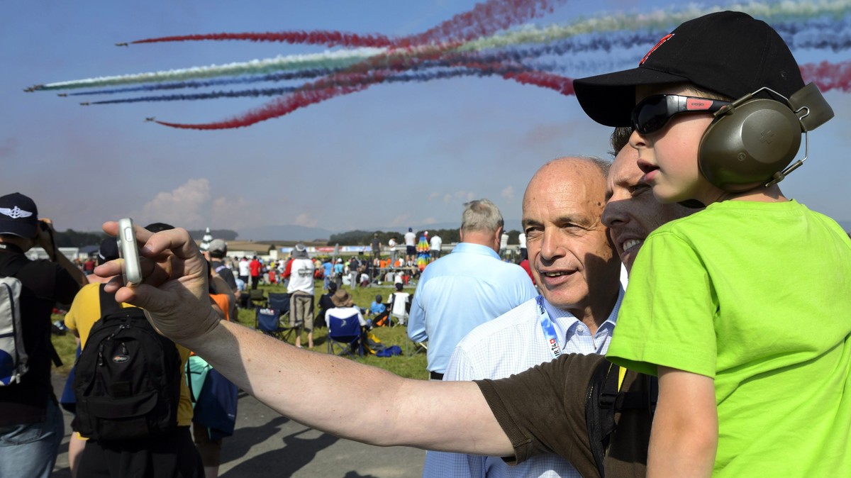 epa04387277 Swiss defence minister Ueli Maurer (3-R) poses for a selfie with spectators as the Jordanian 'Royal Falcons' aerobatics team performs for the visitors of the AIR14 air show, in P ...